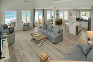 a living room with couches and a table and a kitchen at Shore Looks Good by Pristine Properties Vacation Rentals in Mexico Beach