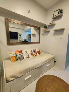 a bedroom with a bed with pillows and a mirror at Primeworld District Condo in Agus