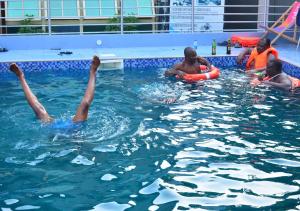 a group of people in a swimming pool at P Meridian Hotels in Awoyaya
