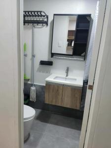 a bathroom with a sink and a toilet and a mirror at Primeworld District Condo in Agus
