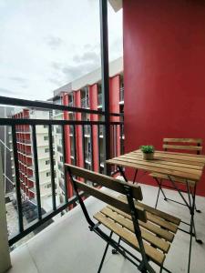 a balcony with a wooden bench and a table at Primeworld District Condo in Agus