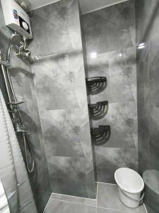 a shower stall with a toilet in a bathroom at Primeworld District Condo in Agus