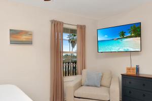 a living room with a tv and a chair and a window at Sun Chaser by Pristine Properties Vacation Rentals in Cape San Blas