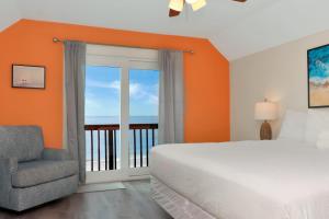a bedroom with a bed and a chair and a balcony at Sun Chaser by Pristine Properties Vacation Rentals in Cape San Blas
