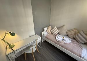 a small bedroom with a bed and a desk at Duplex Royal Château Compiègne in Compiègne