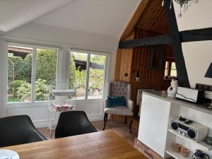 a dining room with a table and chairs and windows at Alte Scheune in Ahrenshoop