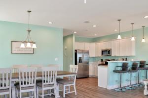 a kitchen and dining room with a table and chairs at Windsong by Pristine Properties Vacation Rentals in Mexico Beach