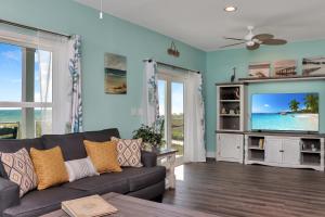 a living room with a couch and a tv at Windsong by Pristine Properties Vacation Rentals in Mexico Beach