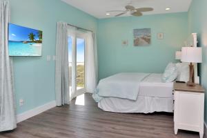 a bedroom with blue walls and a bed and a window at Windsong by Pristine Properties Vacation Rentals in Mexico Beach
