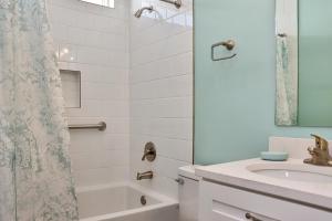 a white bathroom with a sink and a shower at Windsong by Pristine Properties Vacation Rentals in Mexico Beach +43 photos