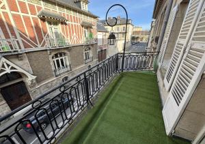 a balcony with green grass on a city street at Duplex Royal Château Compiègne in Compiègne