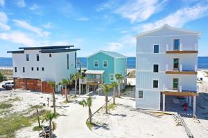 a house on the beach with palm trees at Windsong by Pristine Properties Vacation Rentals in Mexico Beach
