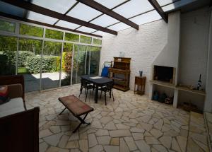 a large living room with a table and a tv at Les libellules in Andernos-les-Bains