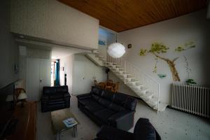 a living room with a couch and a staircase at Les libellules in Andernos-les-Bains
