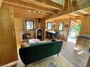 a living room with a green couch and a table at Dom nad Saskiem 3 sypialnie, jacuzzi-relaks, natura i komfort in Linowo