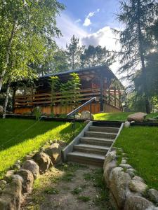 a wooden bridge with stairs in a park at Dom nad Saskiem 3 sypialnie, jacuzzi-relaks, natura i komfort in Linowo