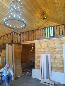 a woman sitting in a room in a wooden house at Zhyrgallaif in Darkan