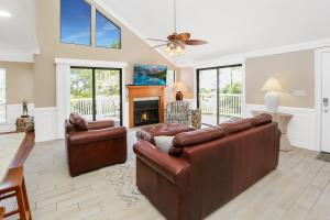 a living room with two leather couches and a fireplace at A Swell Life by Pristine Properties Vacation Rentals in Cape San Blas
