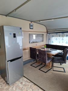 a kitchen with a refrigerator and a table and chairs at Comtesse-Camping Plauer See in Brandenburg an der Havel