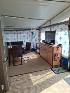 a garage with a table and a tv in it at Comtesse-Camping Plauer See in Brandenburg an der Havel
