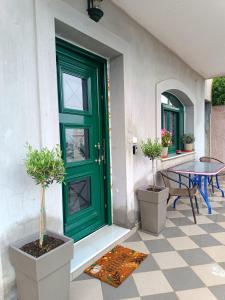a green door on a house with a table and chairs at Argento in Vrontádos