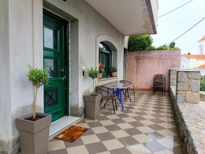 a patio with a green door and a table and chairs at Argento in Vrontádos