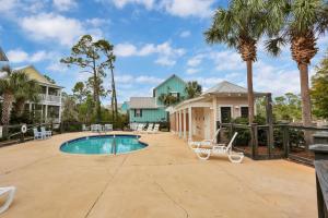 a house with a swimming pool and palm trees at Barefoot Cottage D133 - Beachy Keen by Pristine Properties Vacation Rentals in Highland View