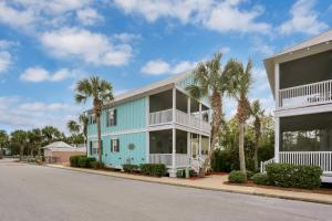 a blue house with palm trees in front of a street at Barefoot Cottage D133 - Beachy Keen by Pristine Properties Vacation Rentals in Highland View