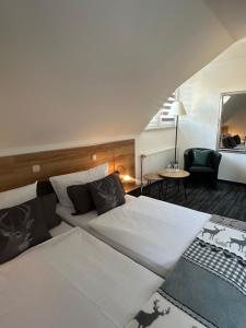 a hotel room with two beds and a chair at Hotel Bergschlößchen in Pockau