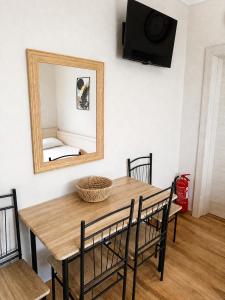 a wooden table with chairs and a mirror on a wall at Stella's House Mangana in Mángana
