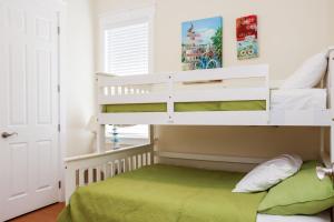 a childs bedroom with a bunk bed with a green bedspread at Waterside Village Cottage 3220 by Pristine Properties Vacation Rentals in Mexico Beach +76 photos