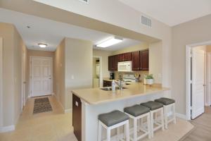a kitchen with a large island with bar stools at Waterside Village Condo 203 by Pristine Properties Vacation Rentals in Mexico Beach