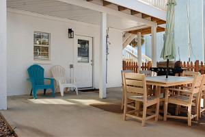 a patio with a table and chairs on a porch at The Ricks Carlton by Pristine Properties Vacation Rentals in Mexico Beach