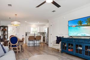 a living room with a tv and a dining room at The Ricks Carlton by Pristine Properties Vacation Rentals in Mexico Beach