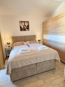 a bedroom with a large bed with two towels at Apartments Aurora in Zadar