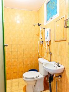 a bathroom with a toilet and a sink at D' Limbai Cottage in Ranau +45 photos
