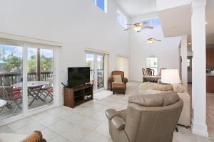 a living room with a couch and a television at Beach Please by Pristine Properties Vacation Rentals in Indian Pass +25 photos