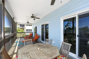 a porch with a wooden table and chairs on it at Beach Please by Pristine Properties Vacation Rentals in Indian Pass