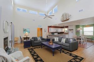 a living room with a couch and a table in it at Boardwalk Sandpiper by Pristine Properties Vacation Rentals in Cape San Blas