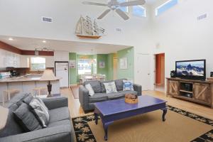 a living room with two couches and a table at Boardwalk Sandpiper by Pristine Properties Vacation Rentals in Cape San Blas