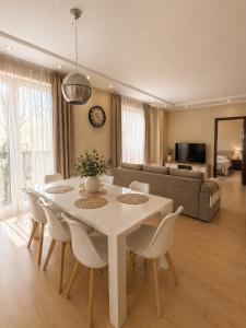a living room with a white table and chairs at Apartamentai Palangoje Arune in Palanga