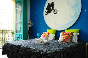 ein blaues Schlafzimmer mit einem Bett mit Mondbild in der Unterkunft Sevilla Kitsch Hostel Art in Sevilla