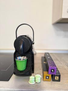 a black tea kettle with a green cup on a counter at Aura Milanese Milano in Milan