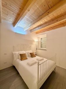 a bedroom with a white bed with a wooden ceiling at Aura Milanese Milano in Milan