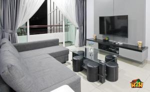 a living room with a couch and a flat screen tv at Majestic Cottage in Ipoh