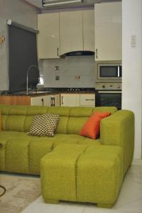 a green couch with colorful pillows in a kitchen at Top city Homes in Lagos
