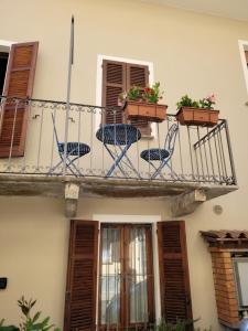 a balcony with chairs and flowers on a building at Ca' Irene in Stresa