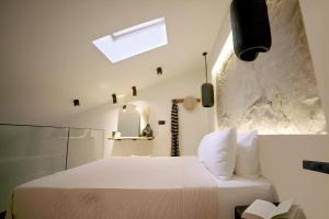 a bedroom with a white bed and a window at ŌMNIMI Signature Living in Skala Potamias