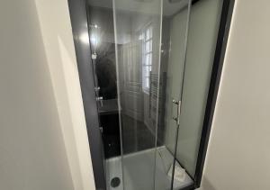 a shower with a glass door in a bathroom at Duplex Royal Château Compiègne in Compiègne +2 photos