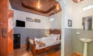 a bedroom with a bed and a sink at Pondok Taksu Bali in Kuta